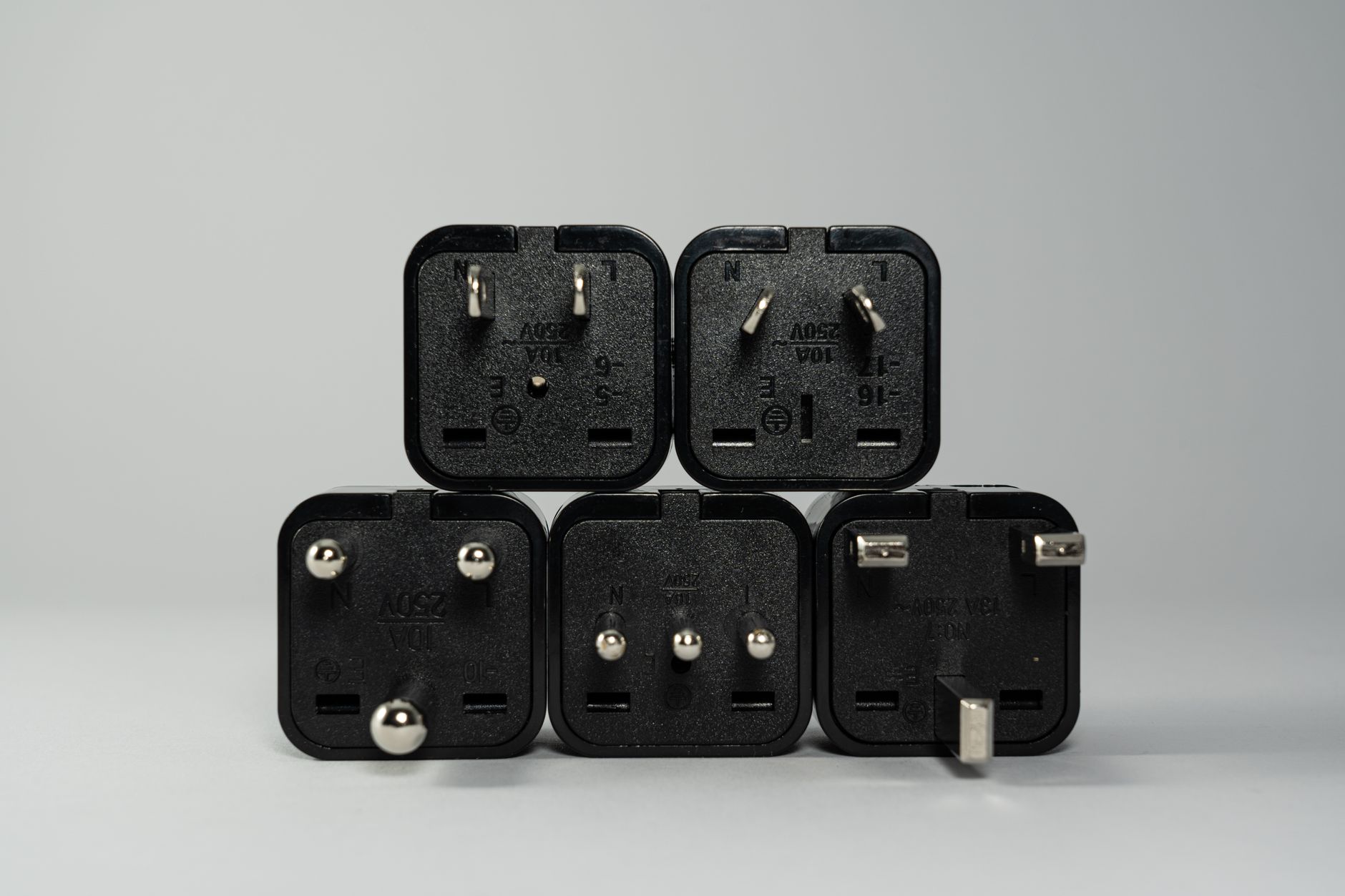 Assortment of international travel adapters laid out on a wooden table