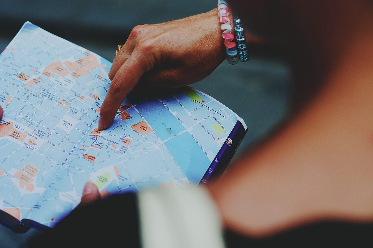 A group of travelers looking at a map at an airport, some holding small translation devices.