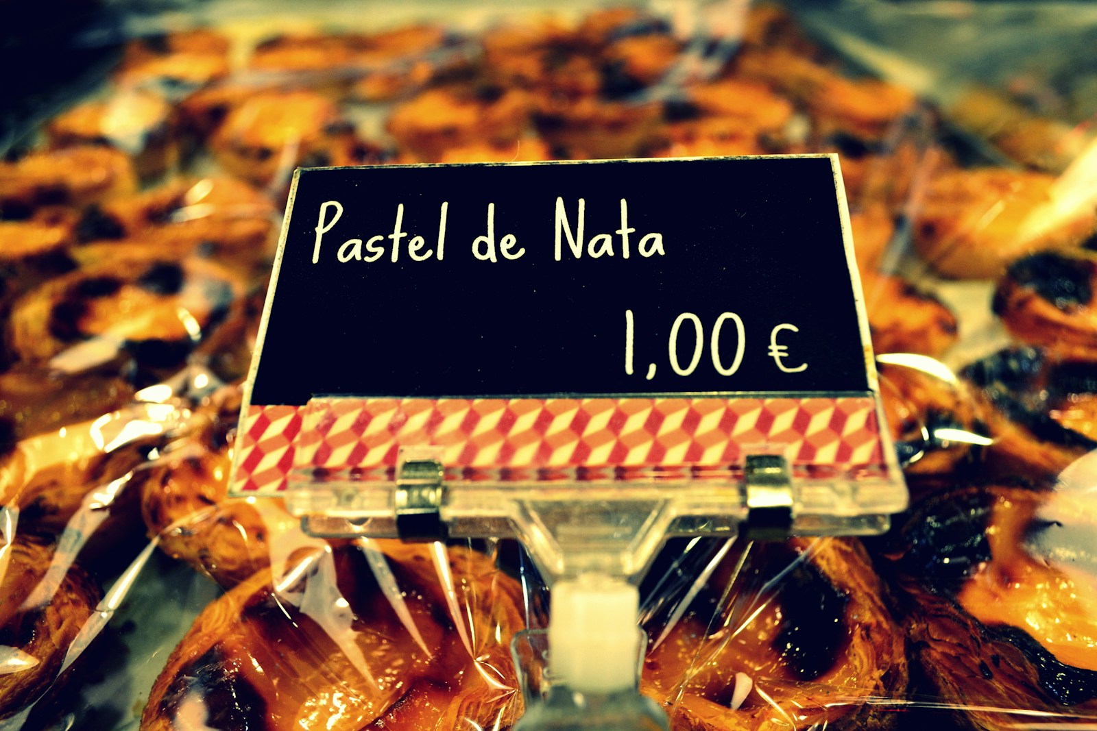 Three pastÃ©is de nata on a plate in a Lisbon bakery