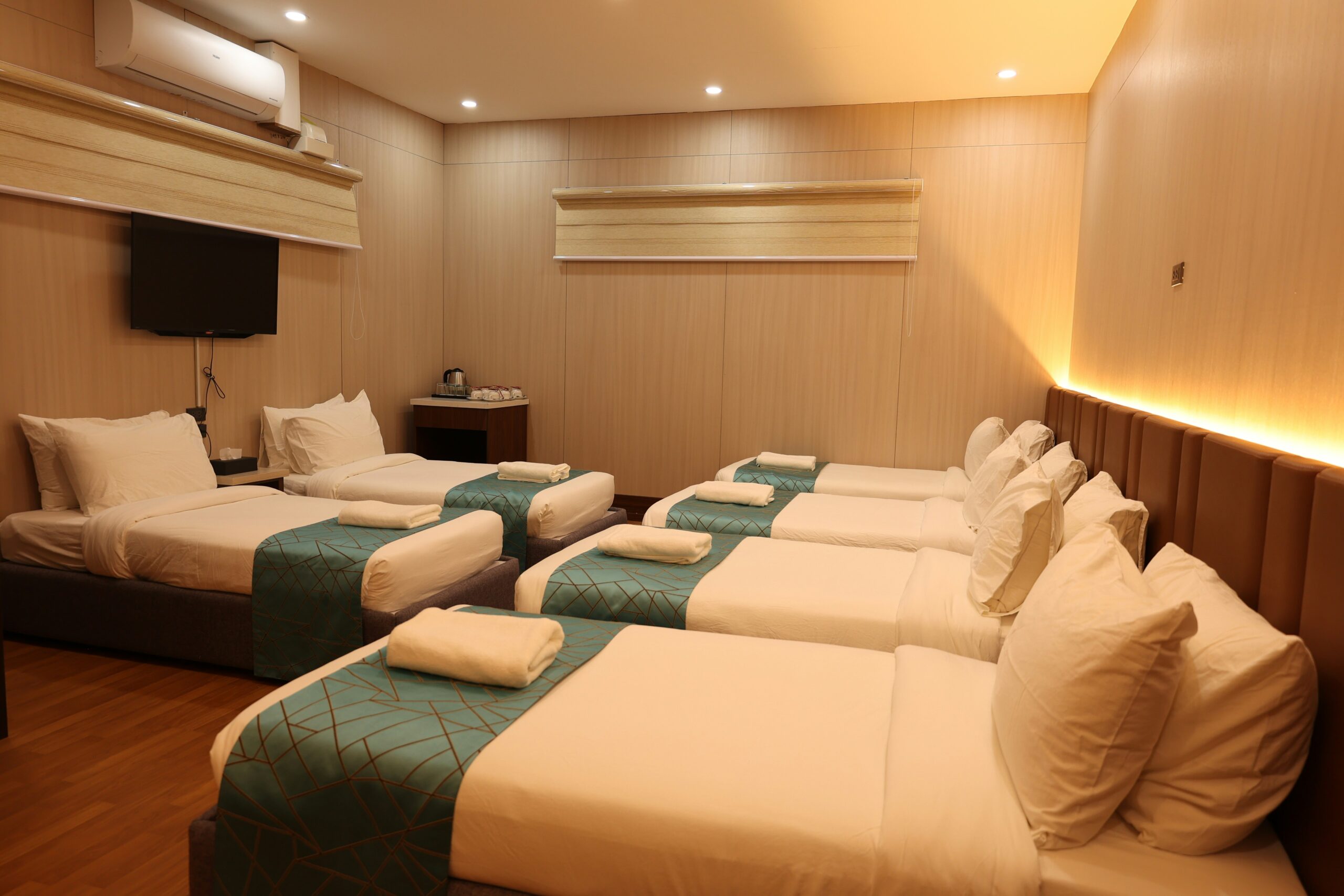 Clean, well-lit room with several neatly made beds.