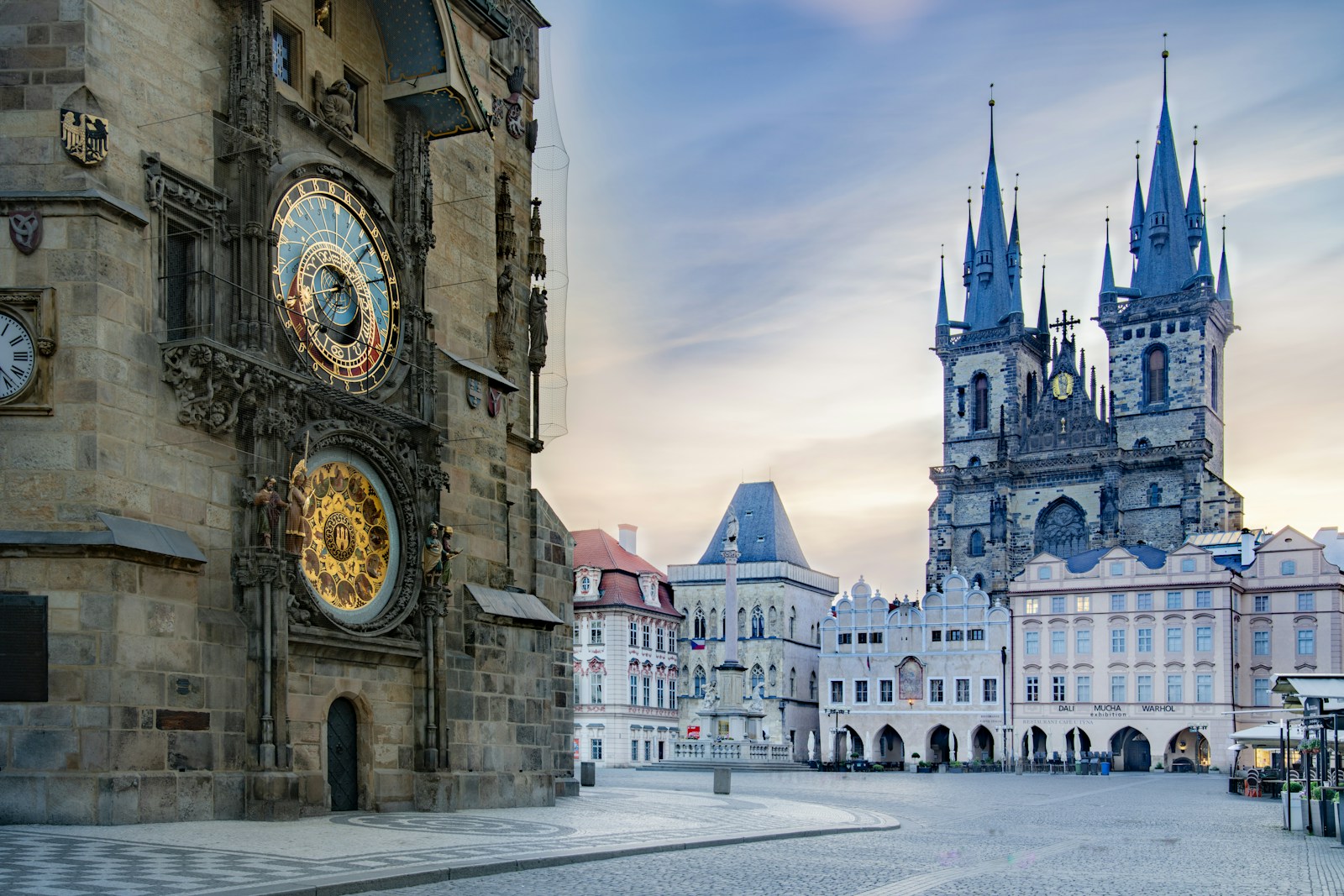 Prague's Old Town Square at sunrise with the Astronomical Clock tower and empty cobblestone square