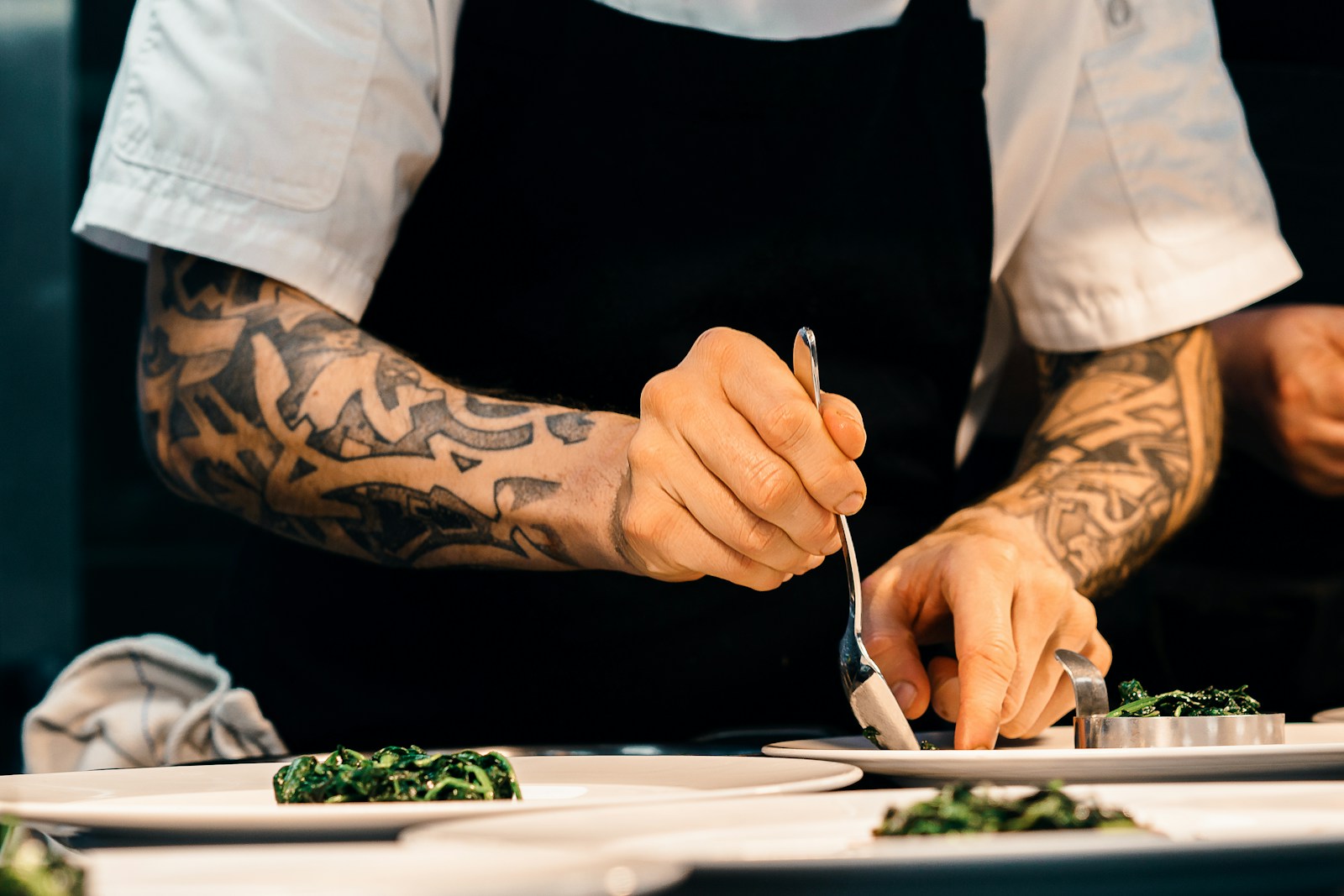 Chef carefully plating a gourmet dish in a professional kitchen