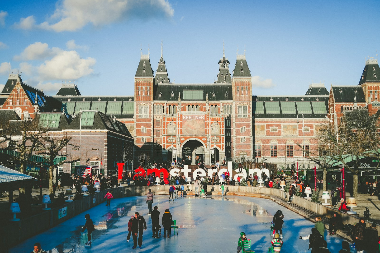 The Rijksmuseum in Amsterdam with visitors walking across the bridge and forecourt