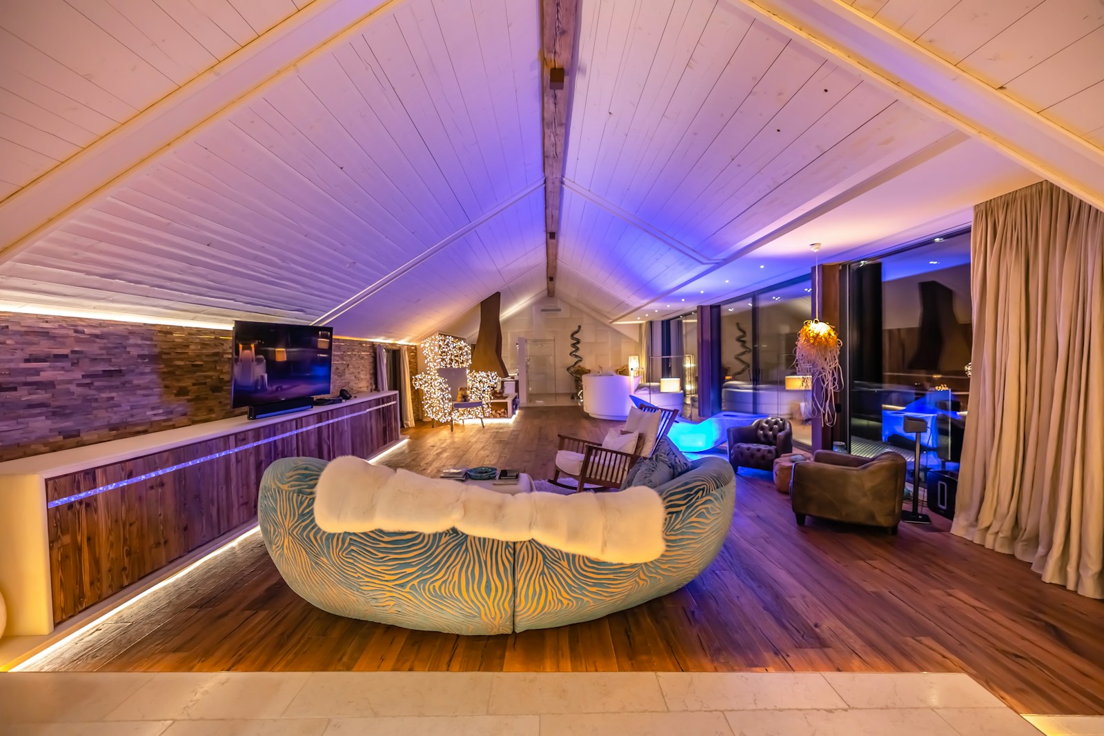 Warm and elegant lobby of a luxury ski hotel with a large stone fireplace and comfortable seating