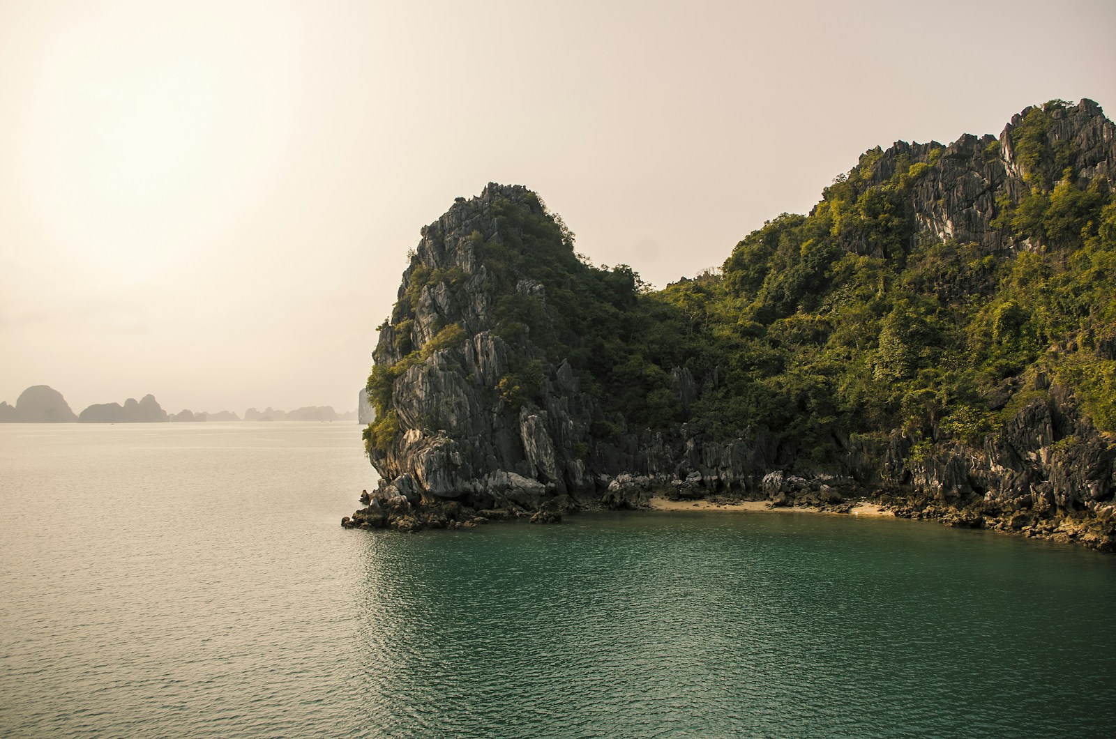 Sunrise over Ha Long Bay with limestone karsts and a cruise ship