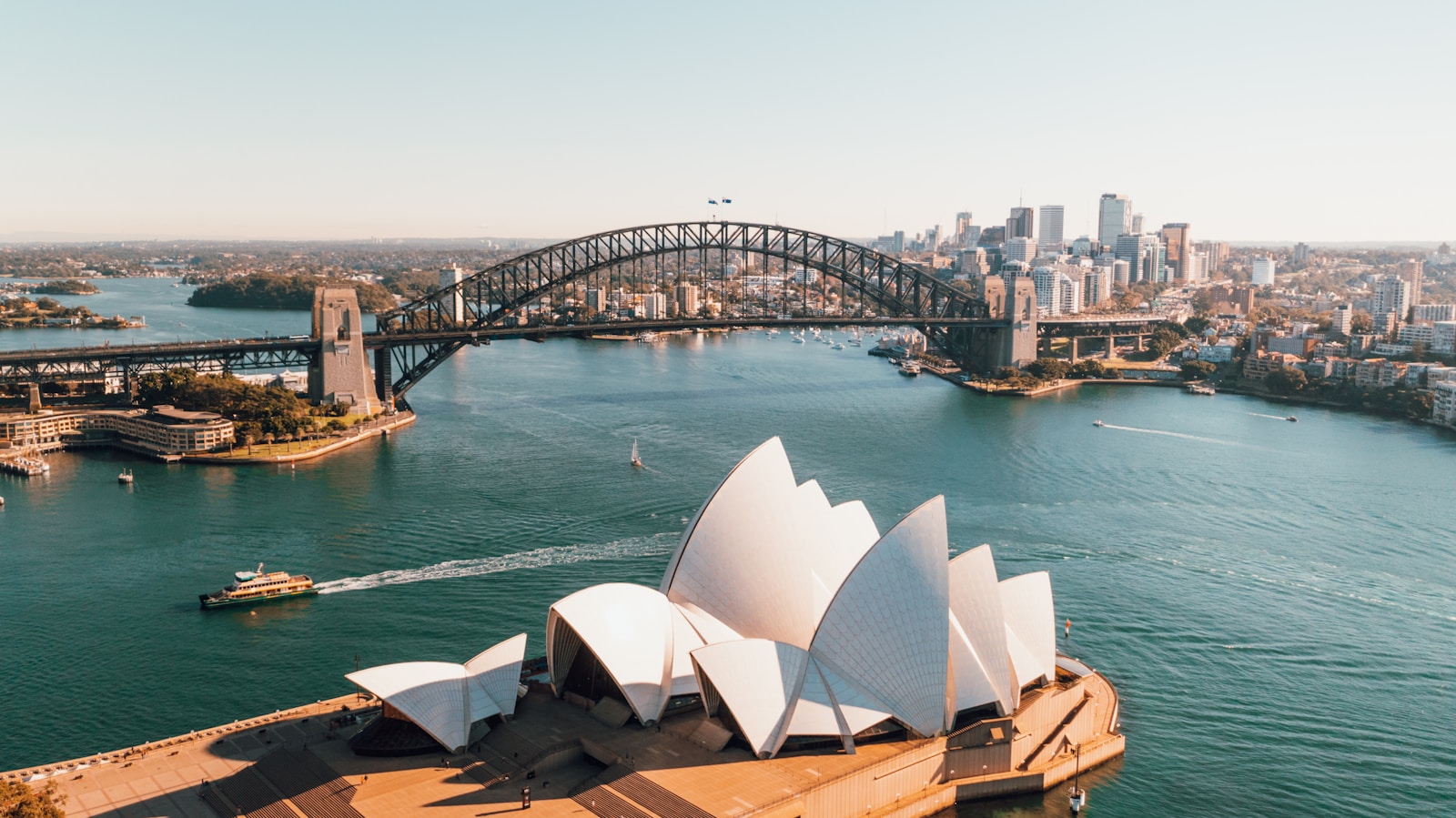 Wide angle view of Sydney Opera House and Harbour Bridge at sunset