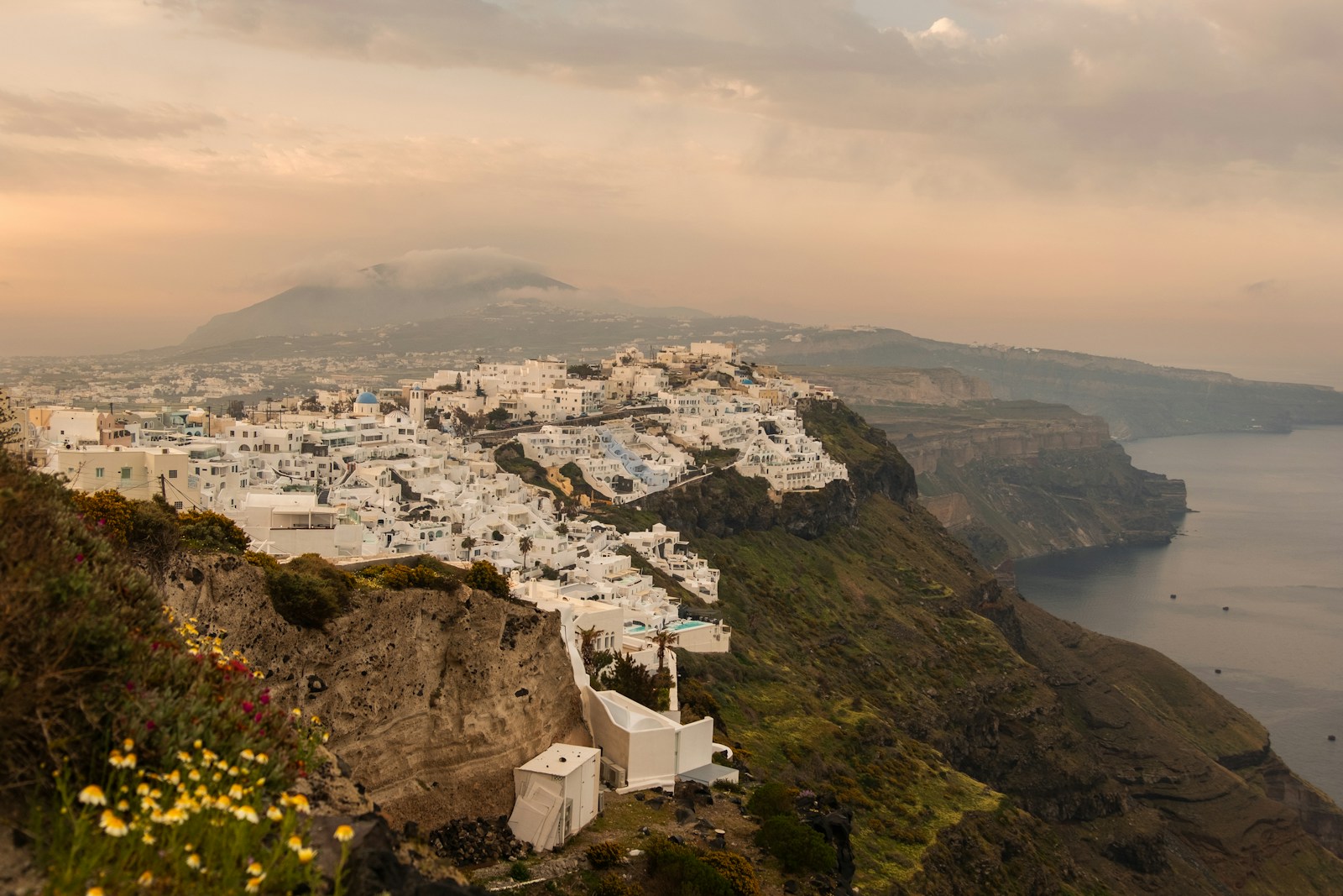 Wide view of Santorini caldera with white-washed buildings and blue-domed churches
