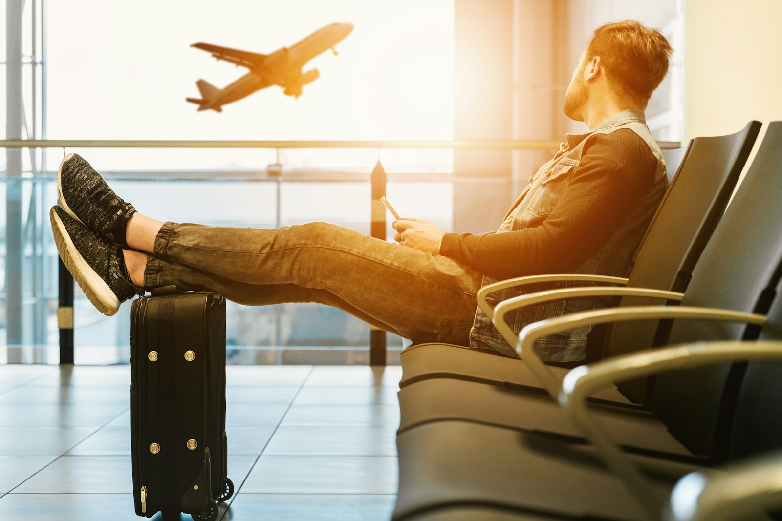 A traveler searches for last minute travel deals on a laptop while sitting at a desk
