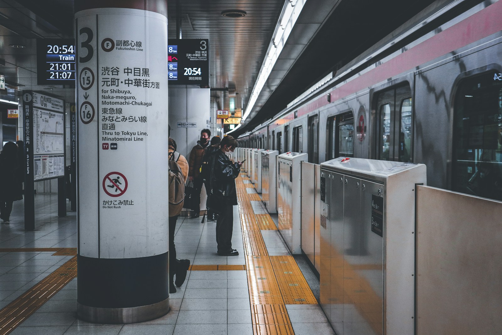 Tokyo train station platform with a Suica card next to a ticket gate