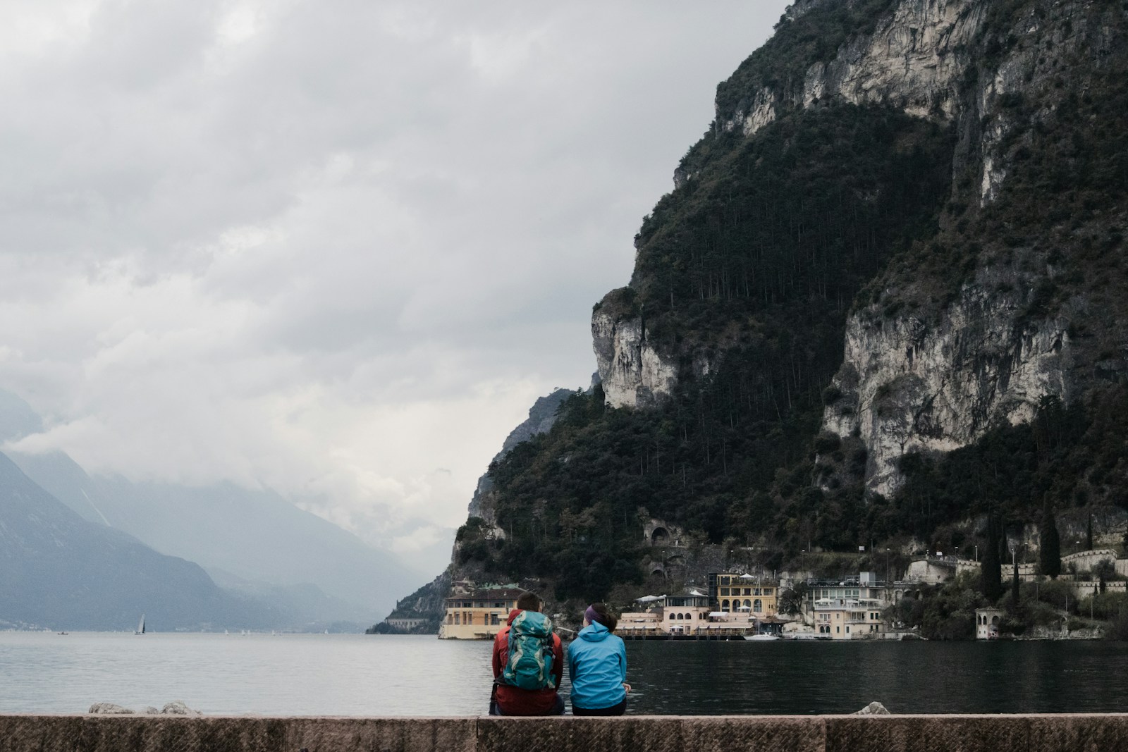 Two solo travelers meet in a cafe with backpacks and a city map, discussing their travel plans