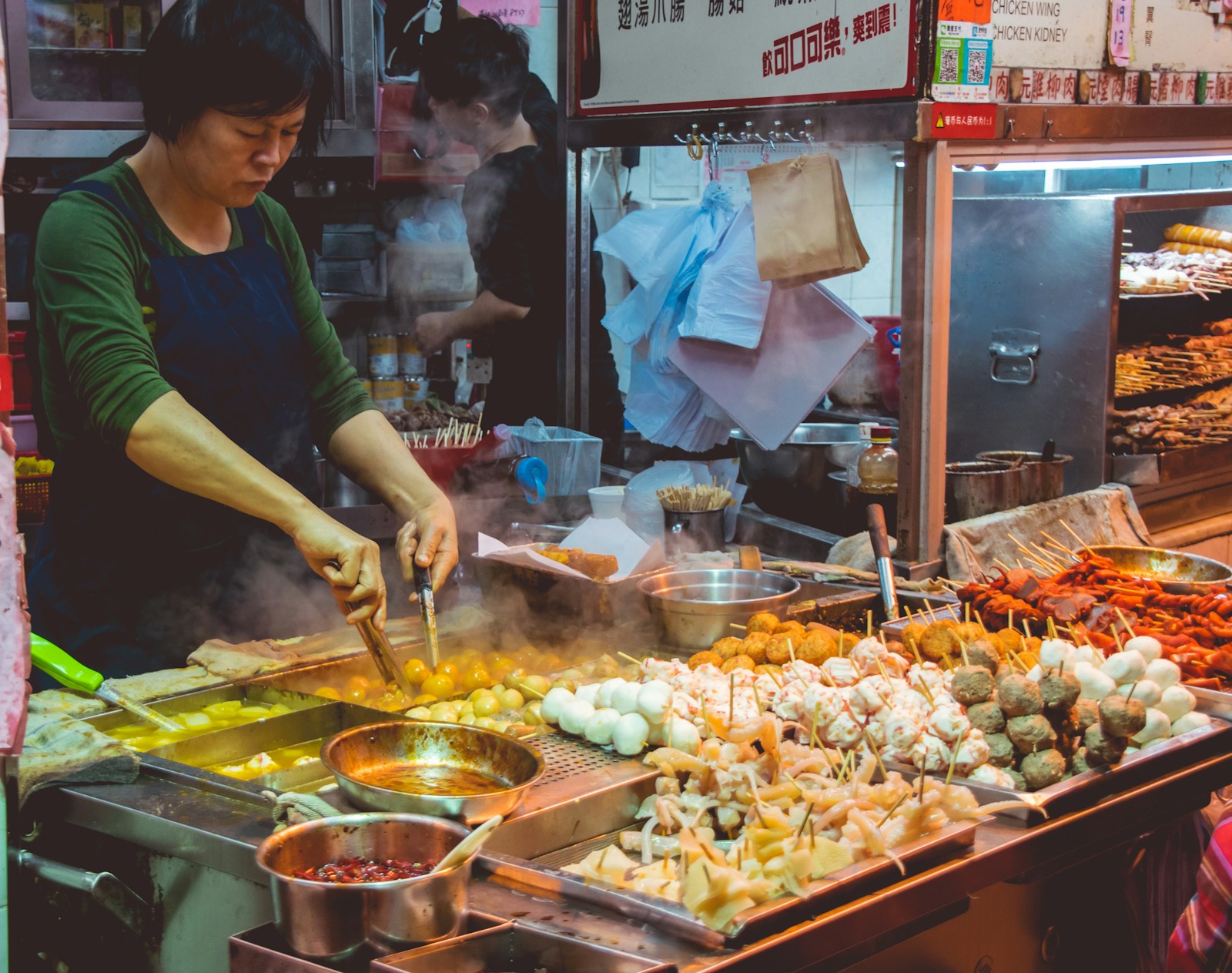 A solo female traveler eating fresh street food at a busy market stall.