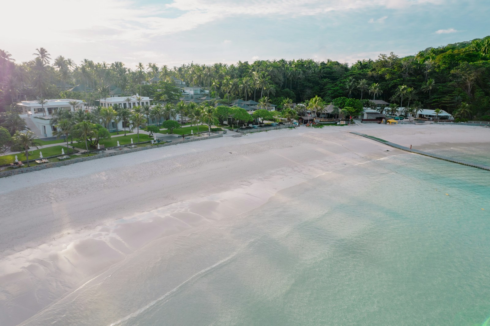 Aerial view of a private island with white sand beach and turquoise water