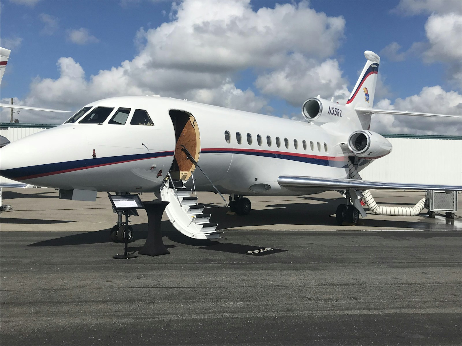 Traveler walking with luggage near a private jet on the tarmac