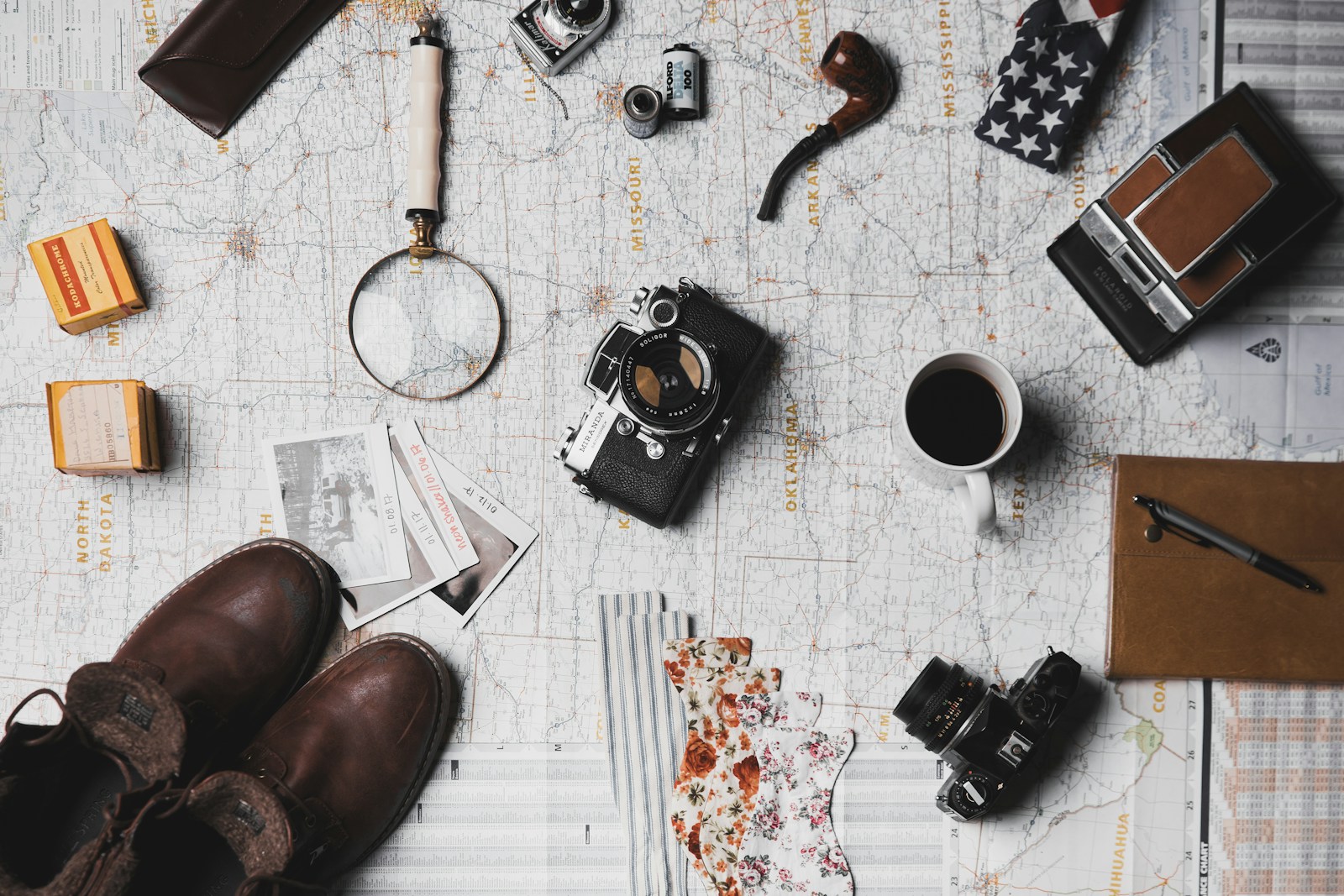 A traveler planning a trip itinerary using a notebook and laptop on a table