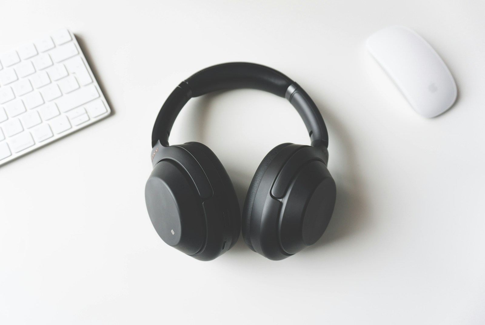 Noise-canceling headphones and a neck pillow placed on an airplane seat