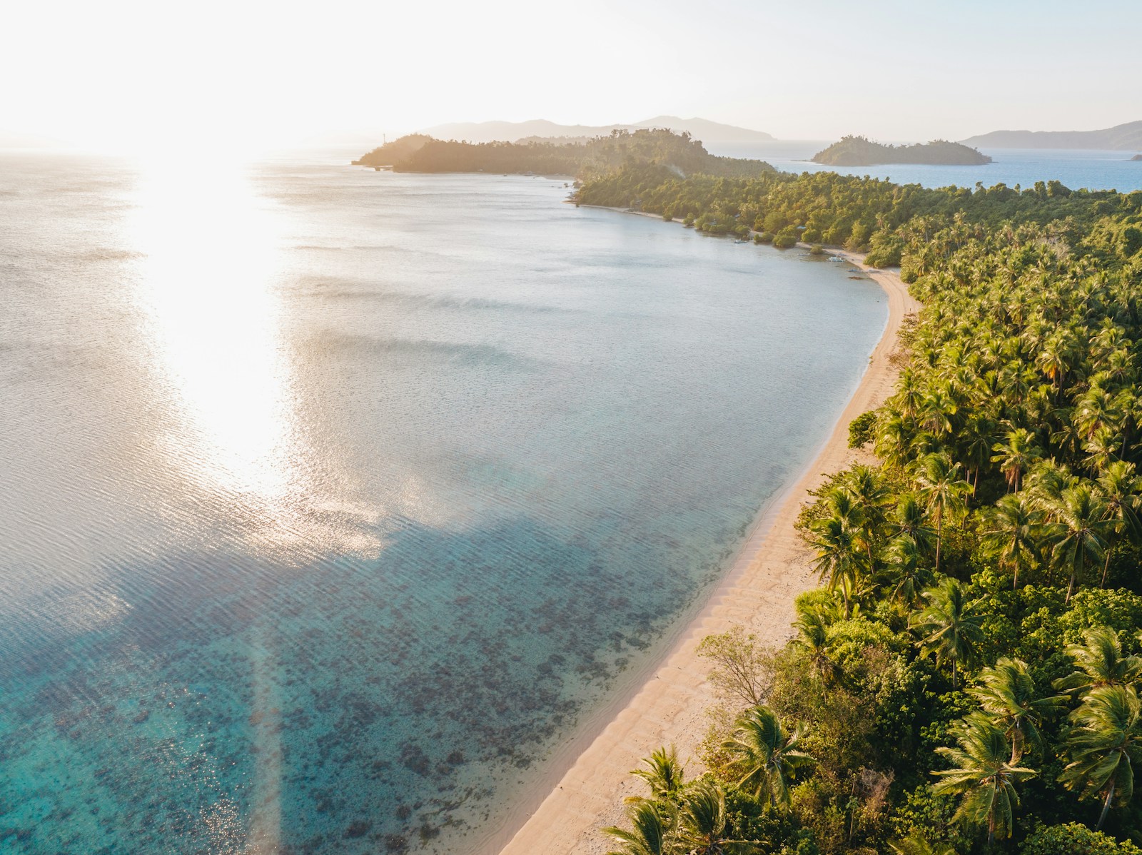 Romantic dinner table set on a private island beach at sunset