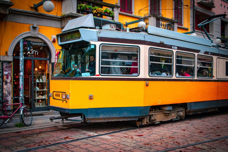 A yellow and blue tram on the tracks.