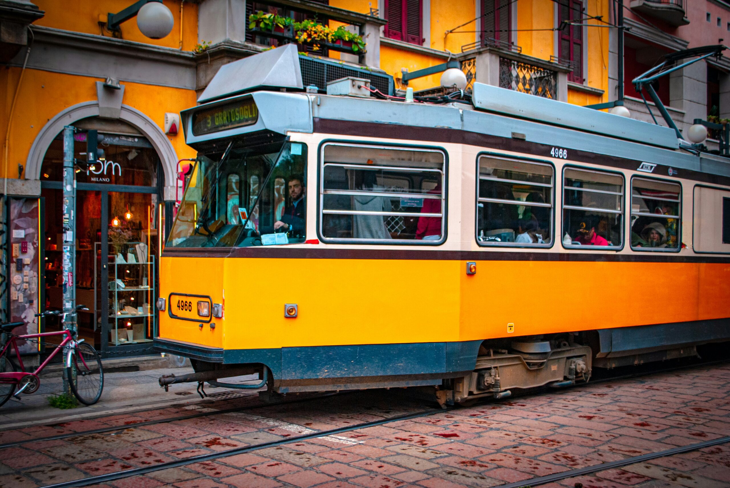 A yellow and blue tram on the tracks.