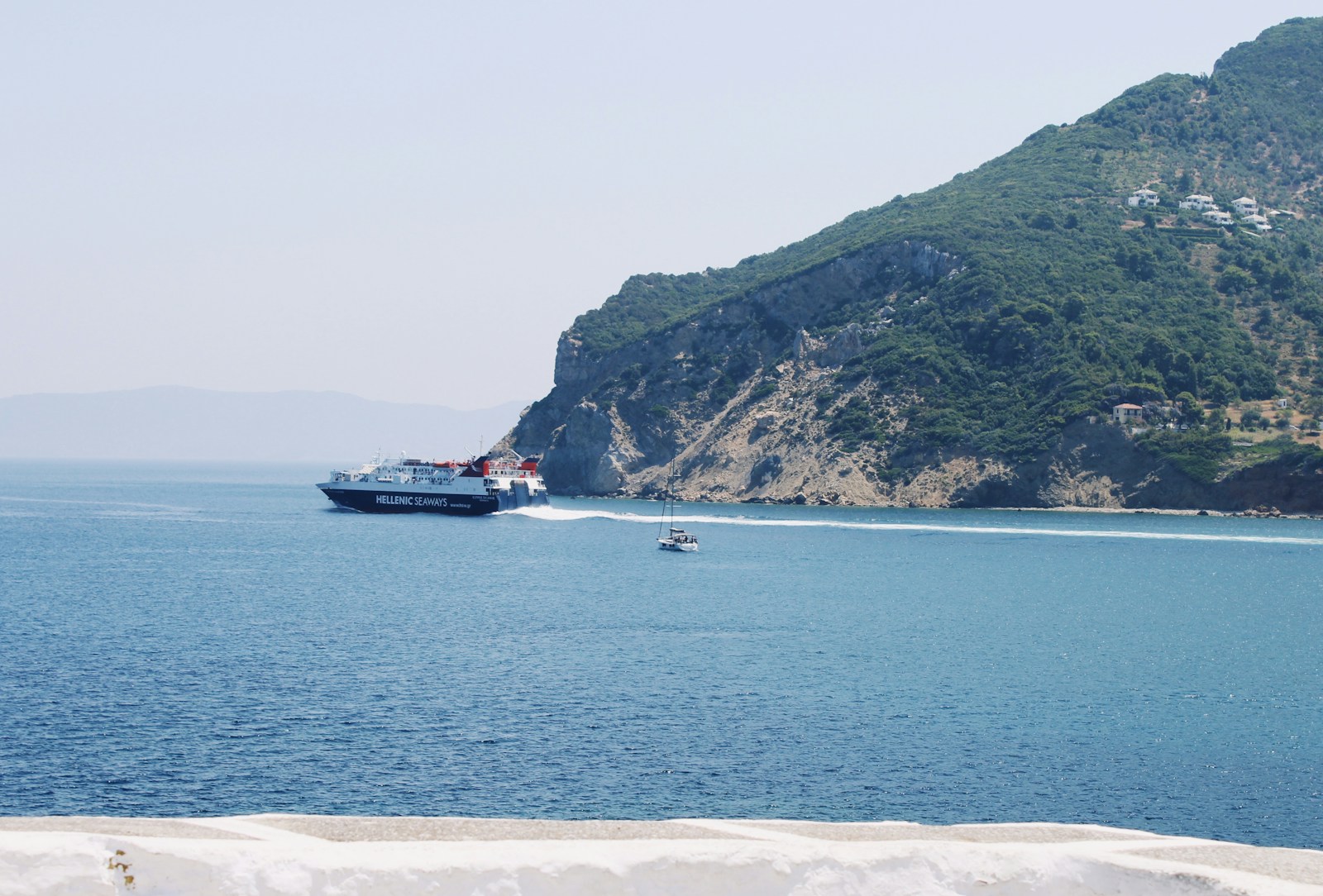High-speed ferry arriving at Athinios port in Santorini with caldera cliffs in the background