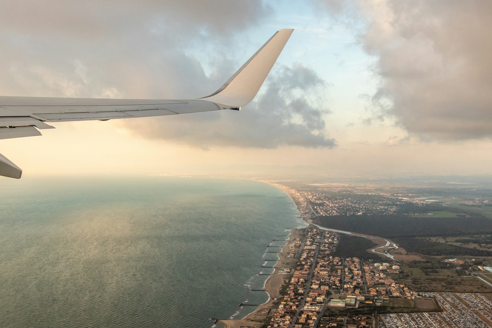 Budget airline airplane flying over ocean at sunset