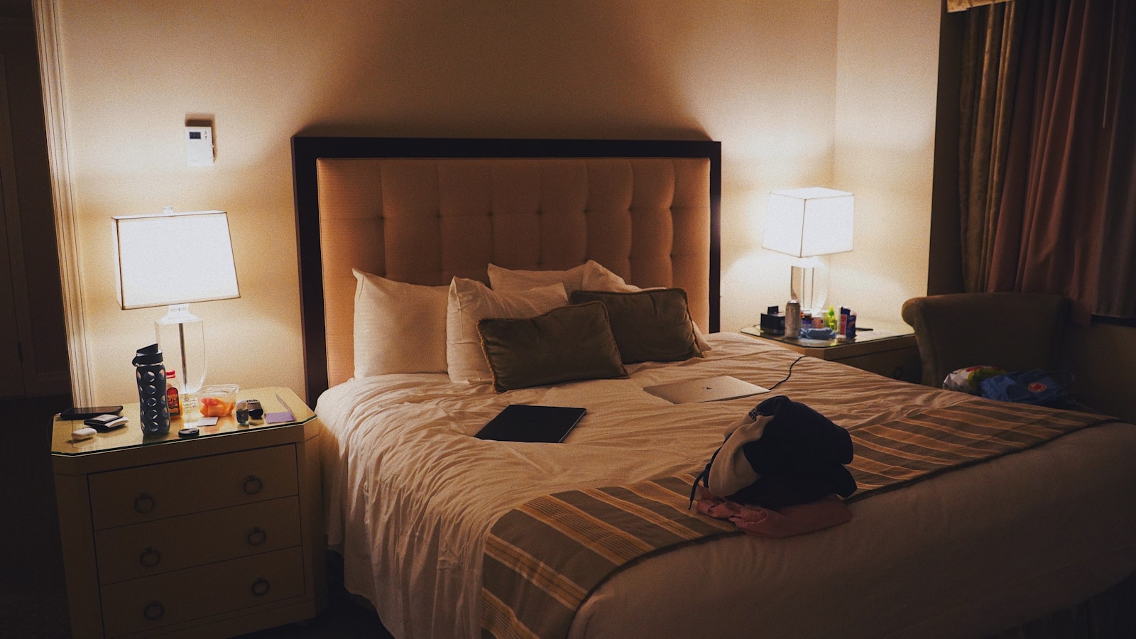 Woman sleeping peacefully in a hotel bed wearing a black eye mask and earplugs