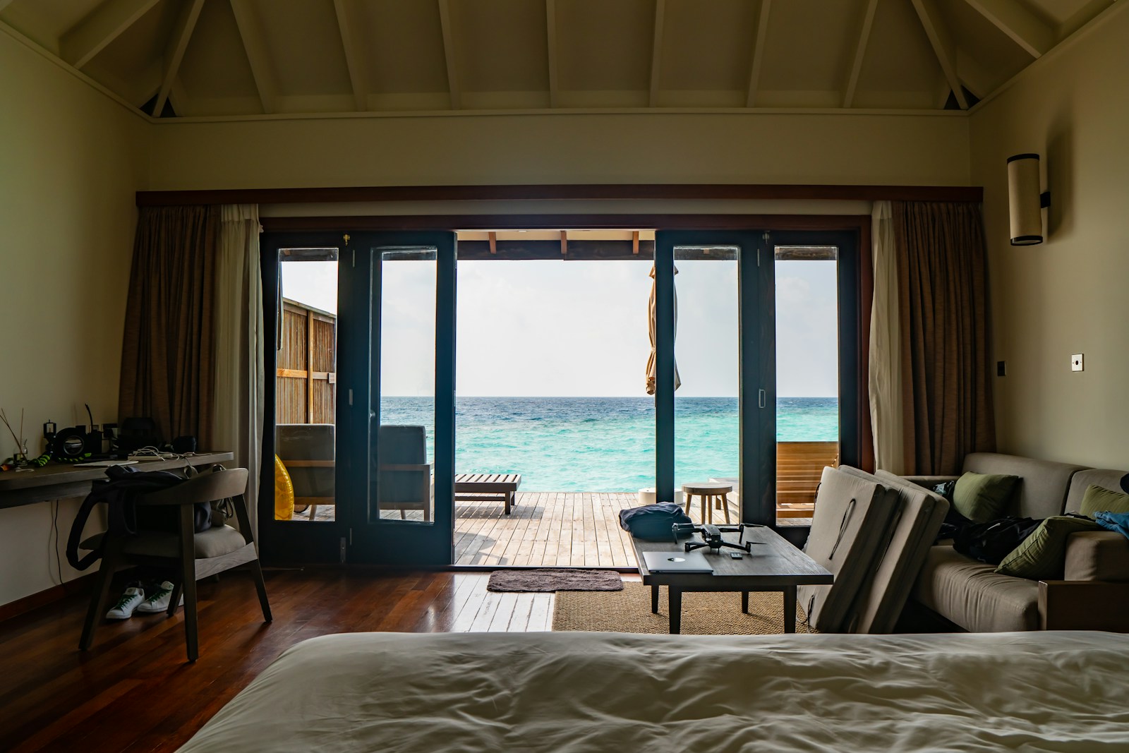 A private overwater villa deck with steps leading into clear blue water