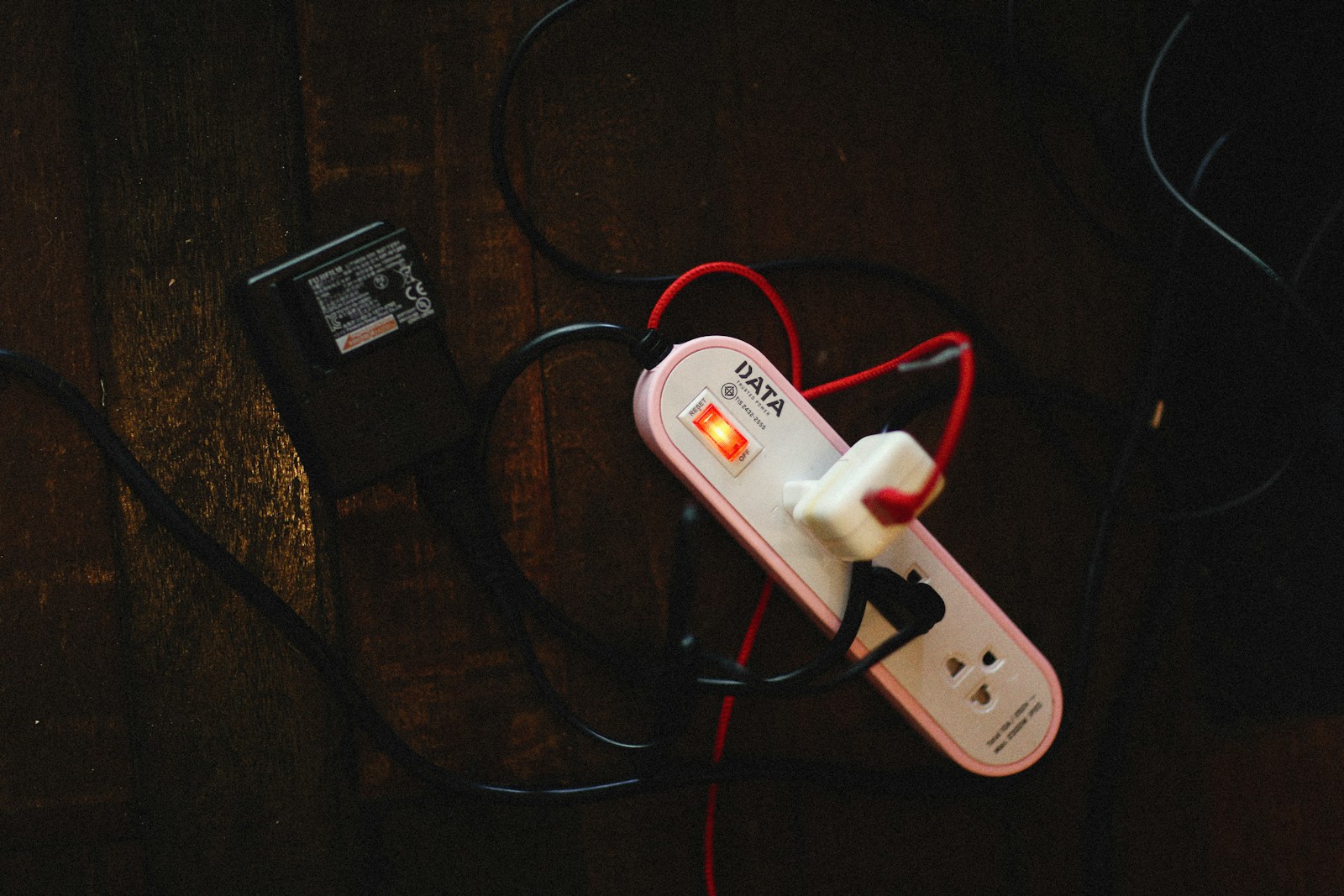 Small travel surge protector power strip with multiple outlets and USB ports on a hotel desk