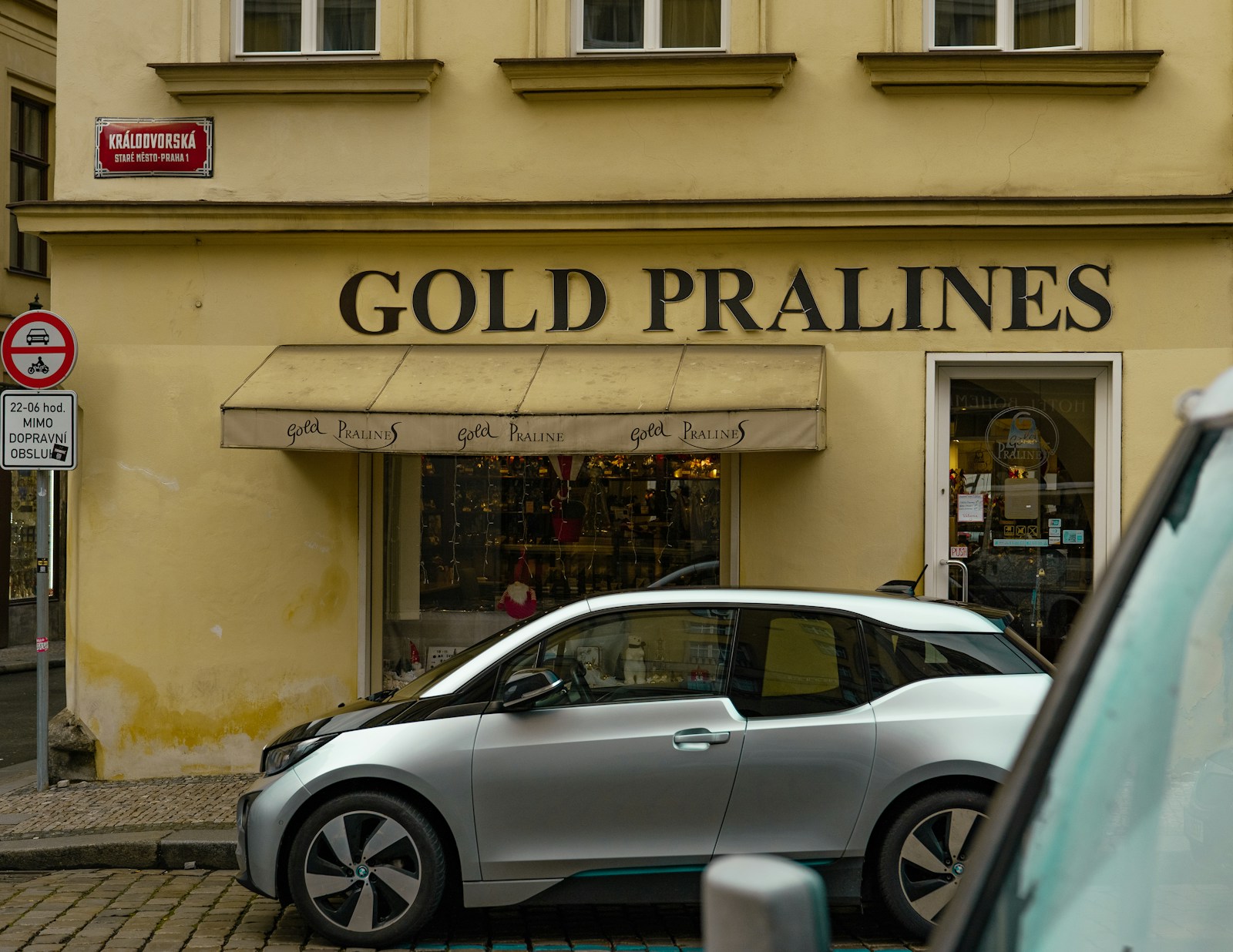 A pair of comfortable walking shoes on a Prague cobblestone street, with a small backpack beside them