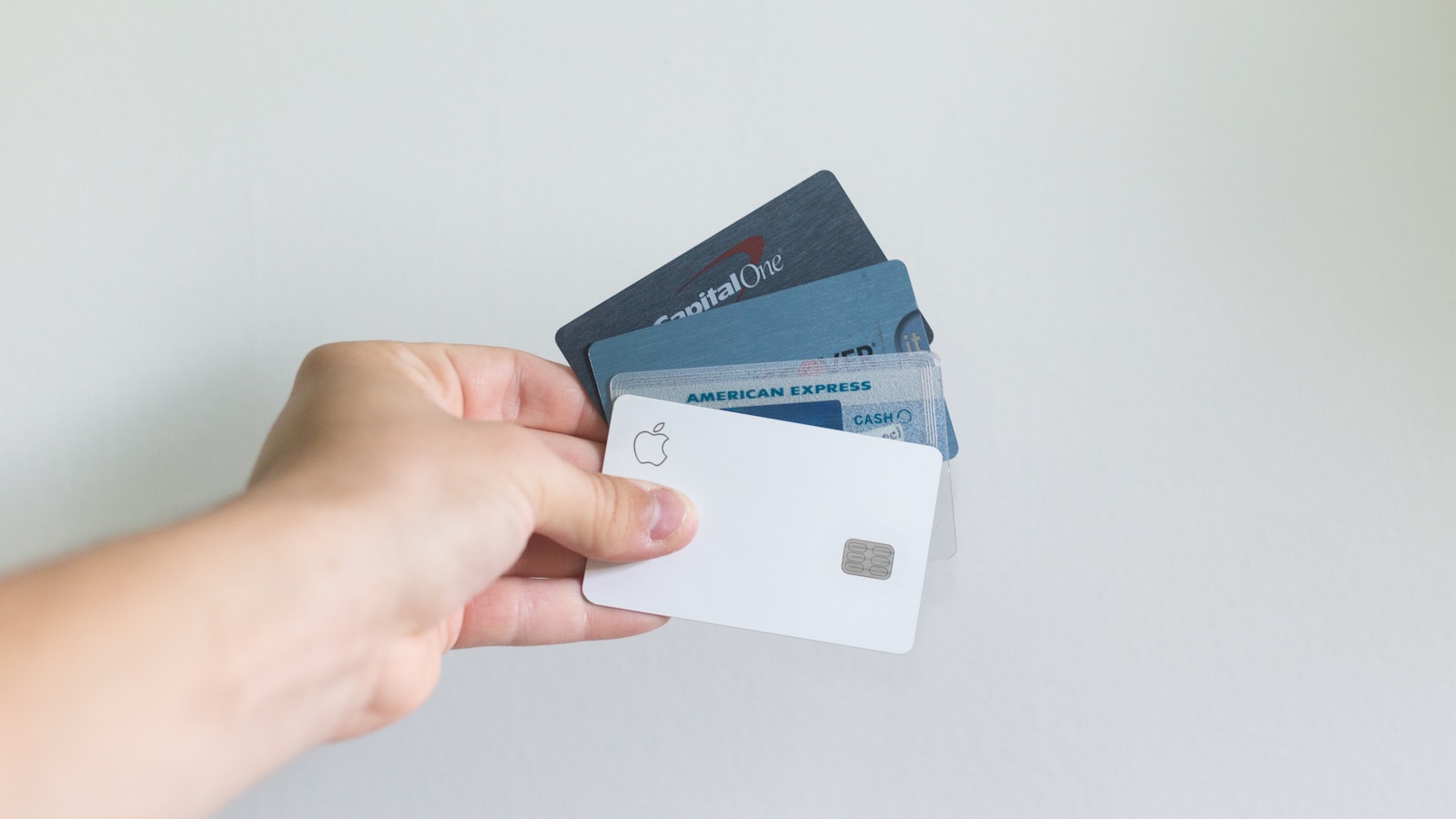 Person holding credit cards while planning travel on a laptop with maps open